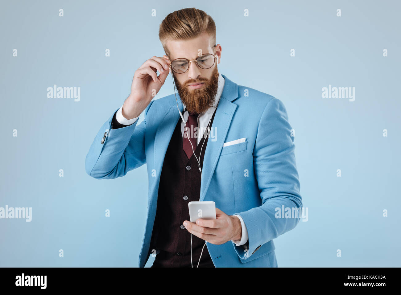 Elegante uomo in auricolari con lo smartphone Foto Stock
