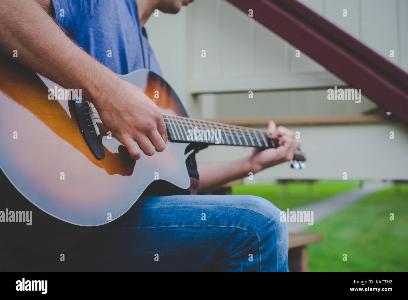 Un giovane uomo riproduce una chitarra. Foto Stock