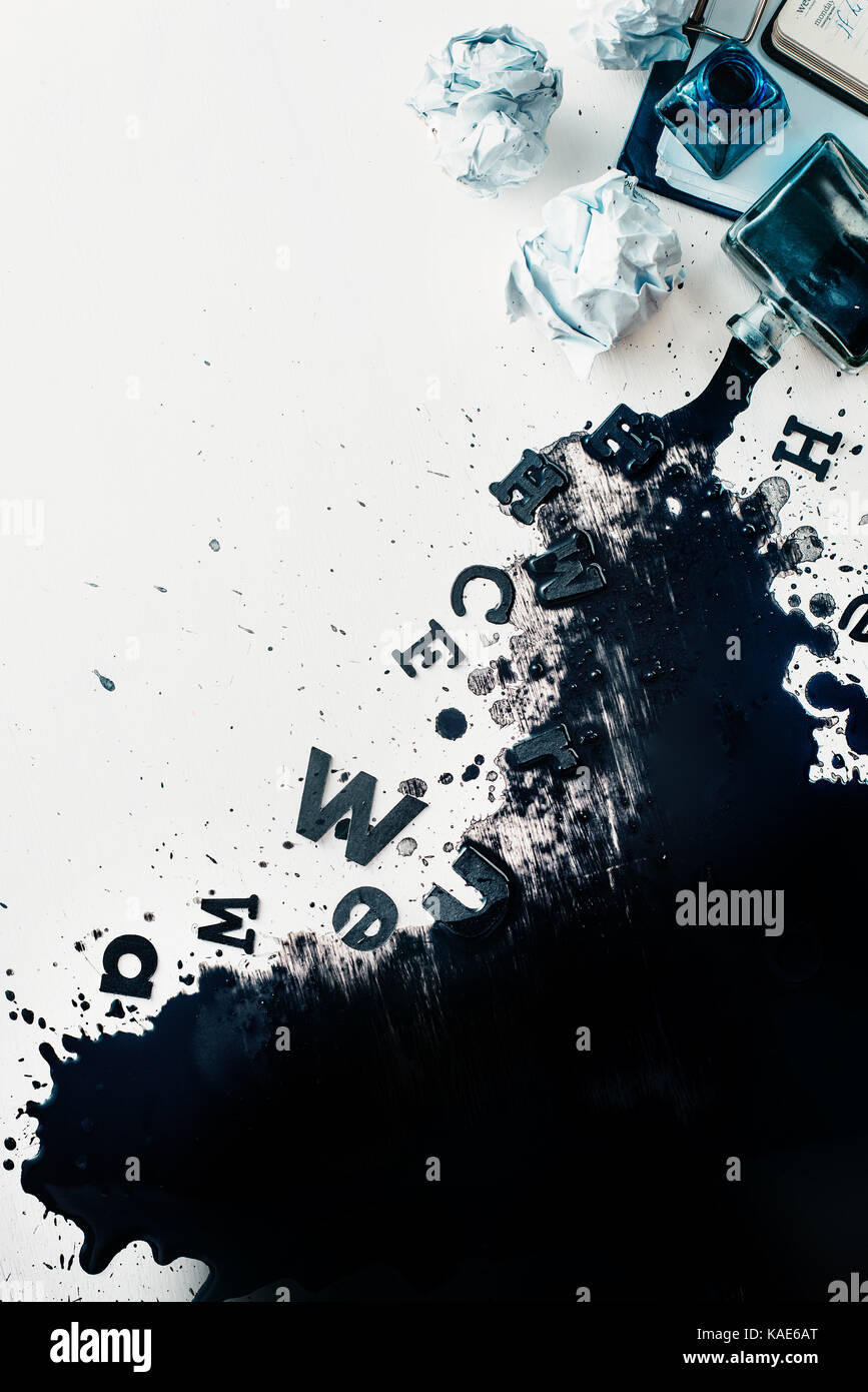 Scrittore workplace con eventuali fuoriuscite di inchiostro, carta sgualcita, sparsi in lettere, carte e taccuini su un bianco sullo sfondo di legno. testata con la scrittura creativa c Foto Stock