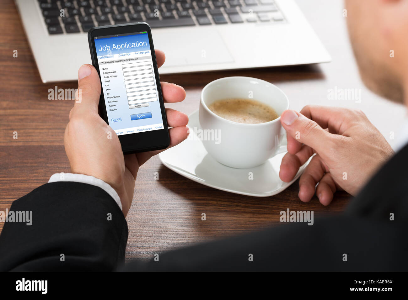 Close-up di un imprenditore in cerca di lavoro sotto forma di applicazione sul cellulare mentre un caffè Foto Stock