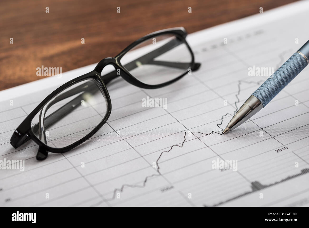 Close-up di penna e occhiali su un foglio di carta millimetrata con schema Foto Stock
