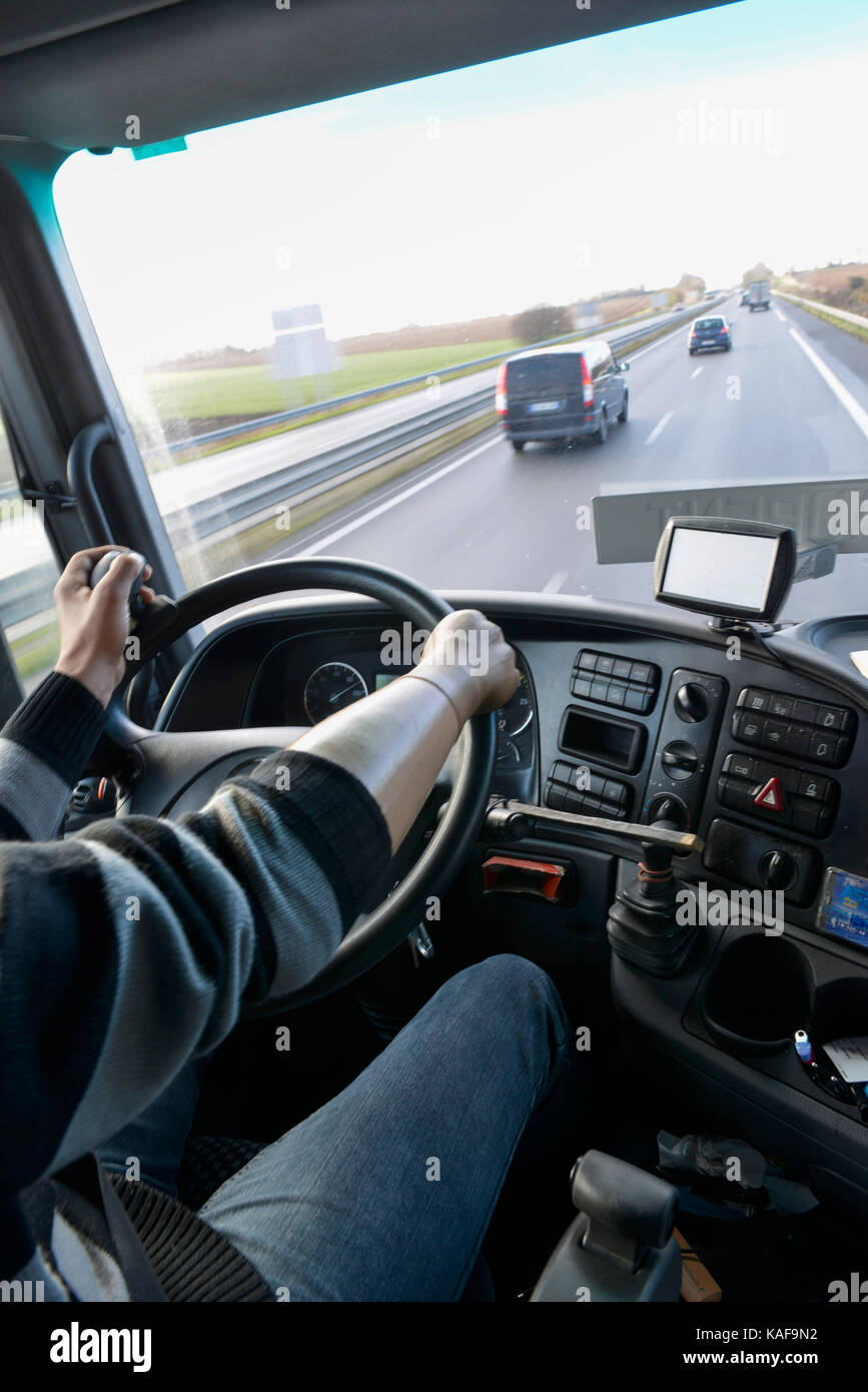 Disabilità, l uomo alla guida di un autocarro con un diritto di mano protesica e perni di guida sul volante per la mano sinistra Foto Stock