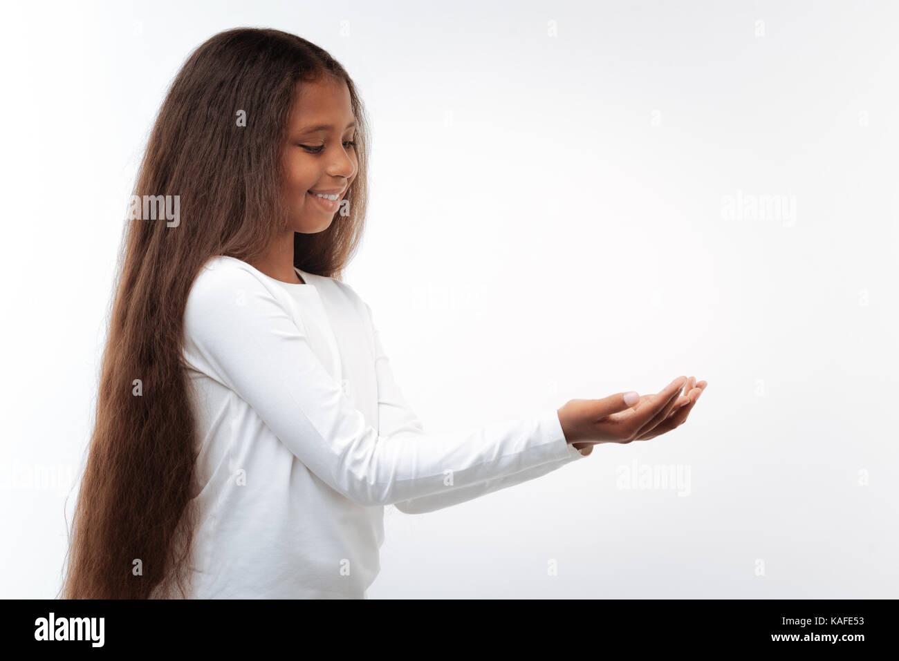 Bella pre-teen ragazza con qualcosa di piccolo nelle sue mani Foto Stock