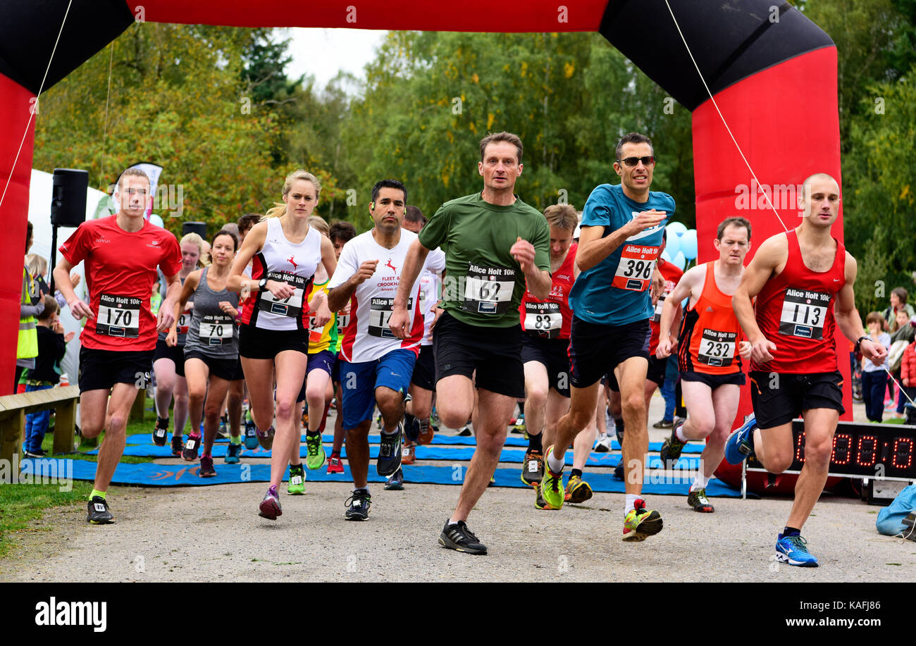 Corridori che prenderanno parte a un 5km & 10km di gara lascia la linea di partenza, Alice Holt foresta, Farnham, Surrey, Regno Unito. Foto Stock