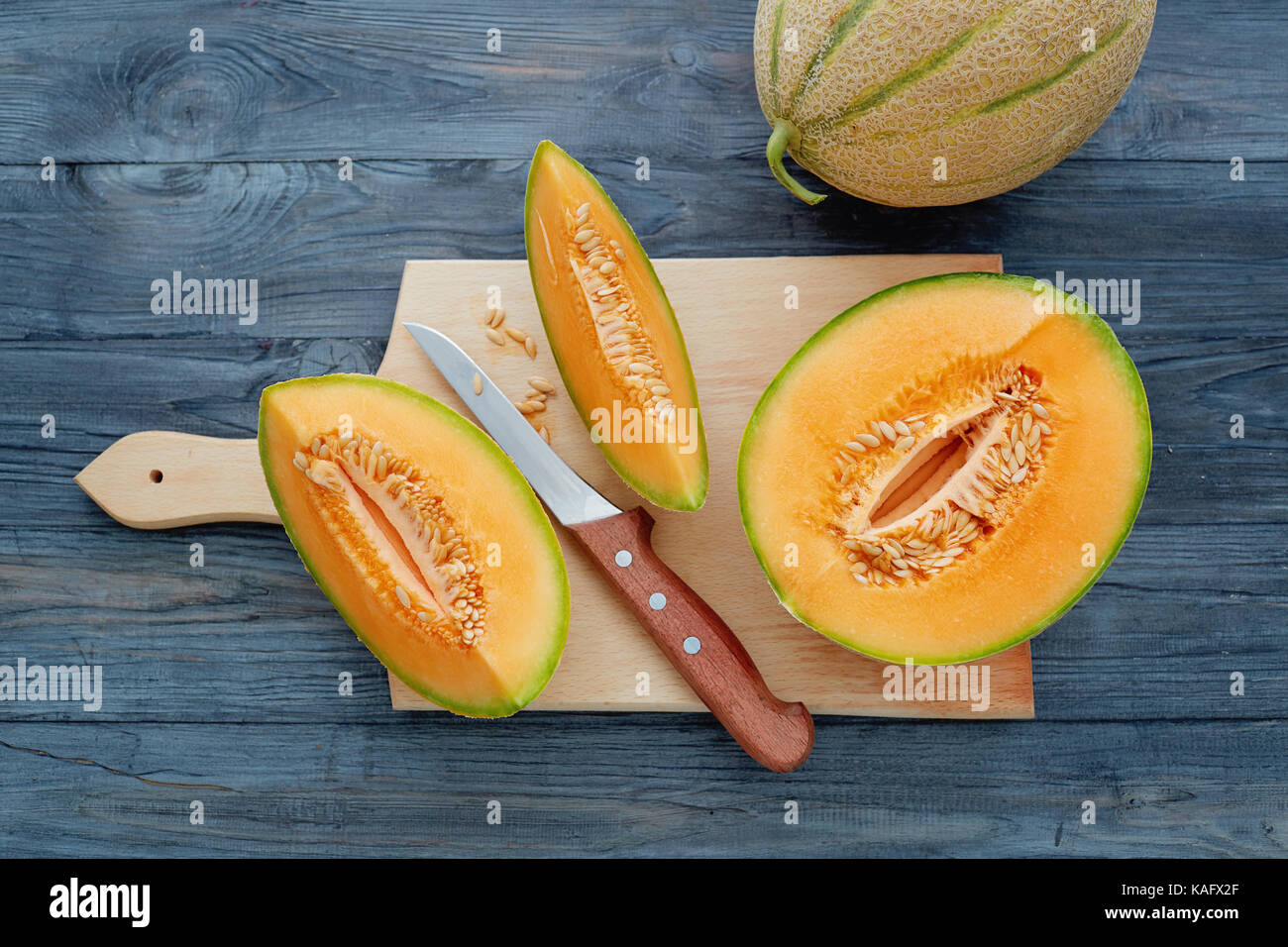 Melone freschi tagliati in pezzi sul tavolo di legno. Foto Stock