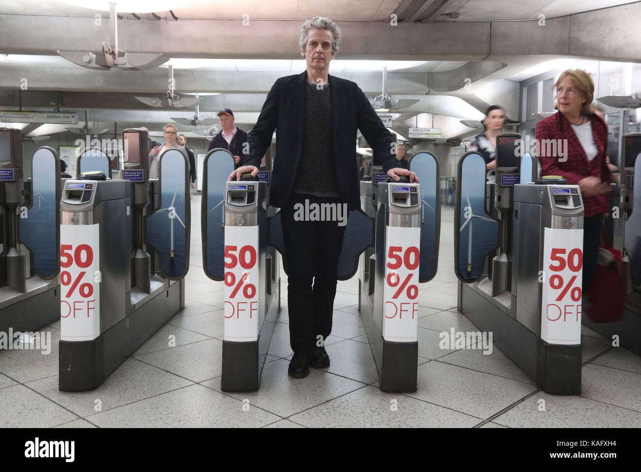 Attore peter capaldi presso la stazione della metropolitana di Westminster dove Greenpeace, il WWF e la marine Conservation Society hanno lanciato una nuova Campagna di supporto eolico offshore come il futuro per il Regno Unito per l'energia tenendo oltre la stazione e collocando Manifesti sui muri e porte di biglietto con il messaggio che l'elettricità da energia eolica offshore è la metà del prezzo è stato appena due anni fa. Foto Stock