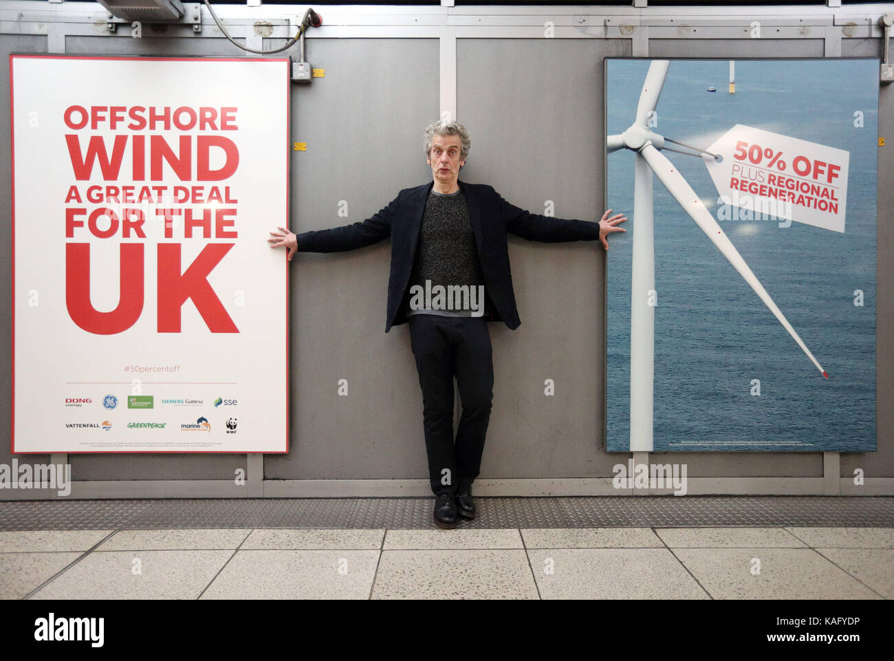 Attore peter capaldi presso la stazione della metropolitana di Westminster dove Greenpeace, il WWF e la marine Conservation Society hanno lanciato una nuova Campagna di supporto eolico offshore come il futuro per il Regno Unito per l'energia tenendo oltre la stazione e collocando Manifesti sui muri e porte di biglietto con il messaggio che l'elettricità da energia eolica offshore è la metà del prezzo è stato appena due anni fa. Foto Stock