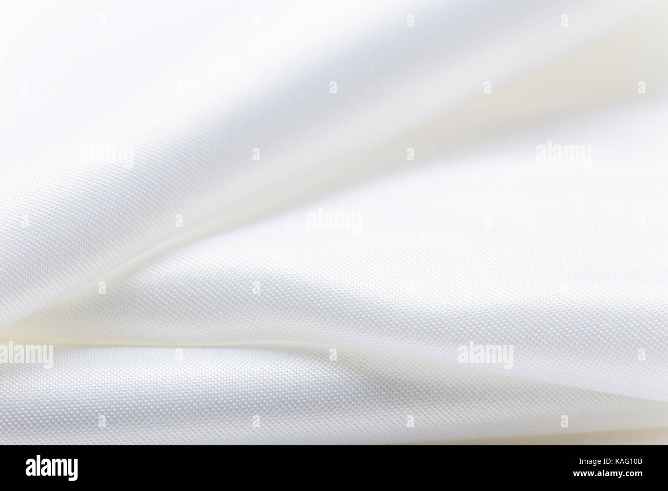 Piegate il tessuto bianco, mostrando la sua consistenza e lucentezza, buona per utilizzo come tema tessile sfondo Foto Stock
