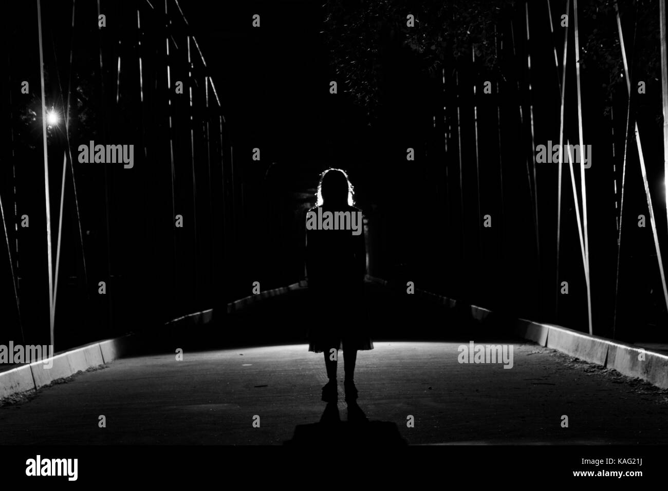 Silhouette della ragazza scuro su un ponte Foto Stock