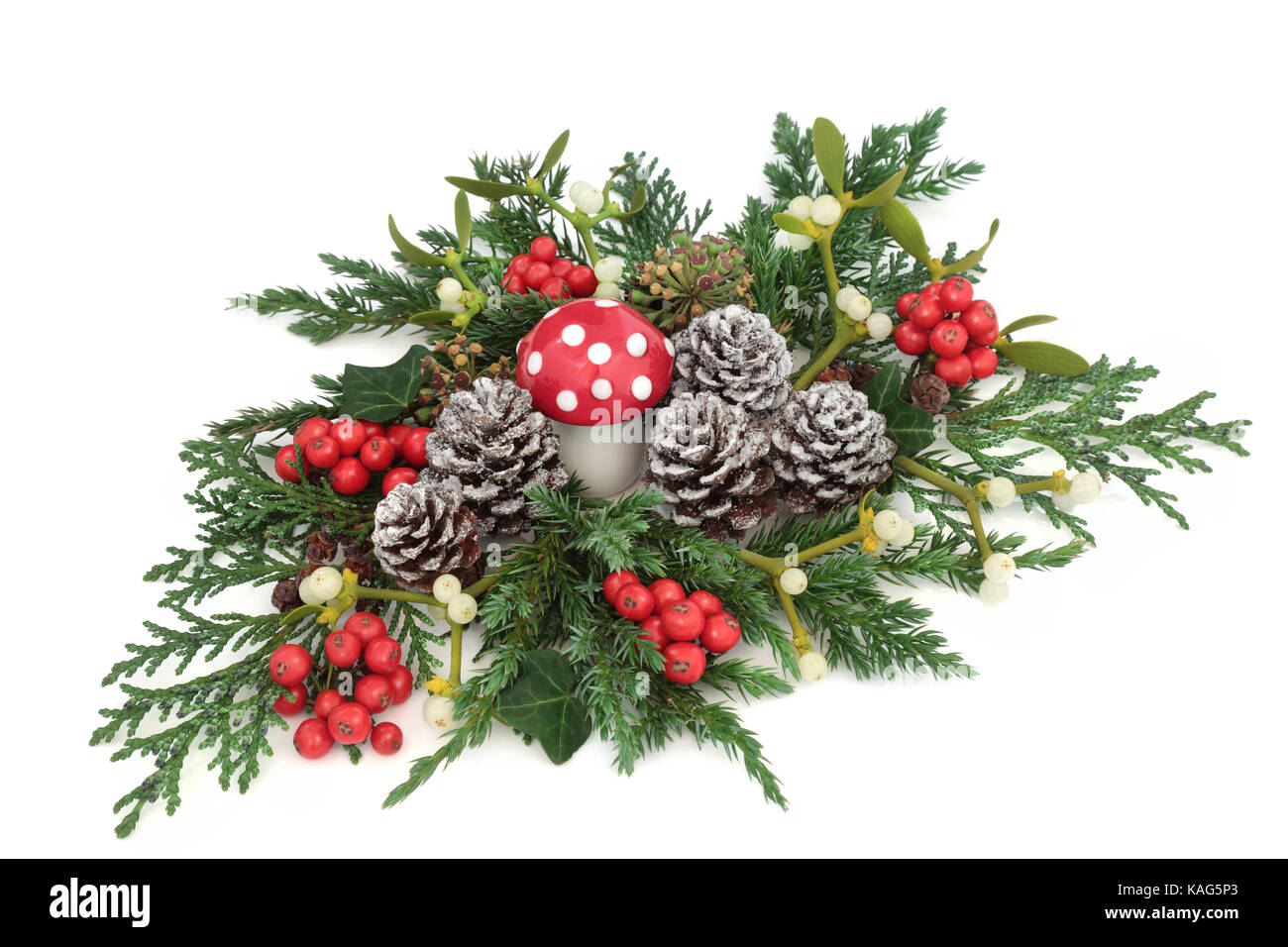 Inverno di fantasia e la decorazione di Natale con fly agaric ornamento fungo, agrifoglio, edera, vischio, edera, ginepro e cedro cipresso foglie e rametti di pine Foto Stock