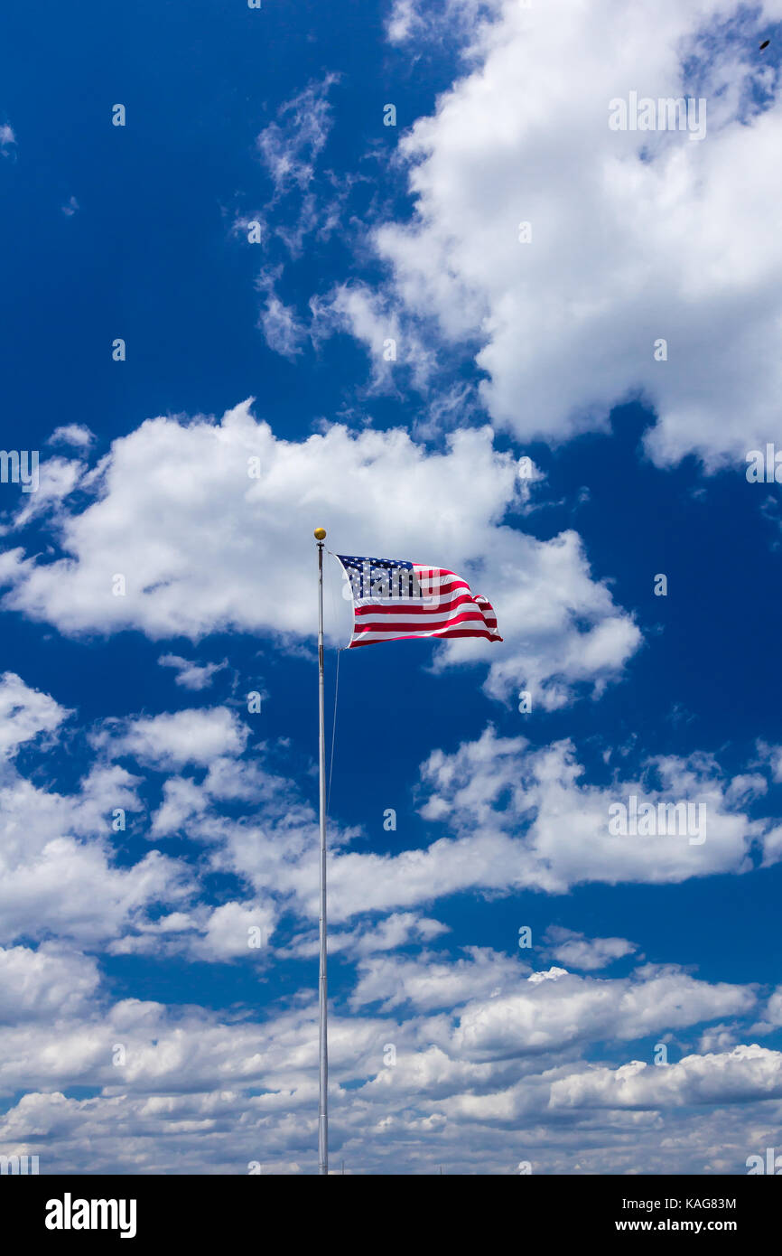 Bandiera americana contro il cielo blu con le montagne sullo sfondo. Foto Stock