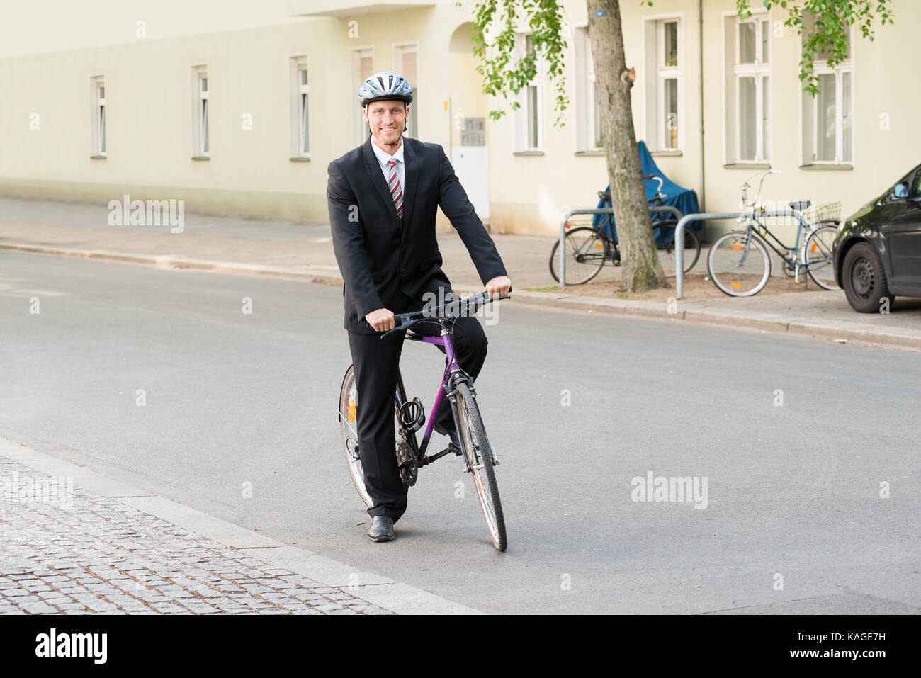 Ritratto di un happy businessman equitazione sulla sua bicicletta Foto Stock