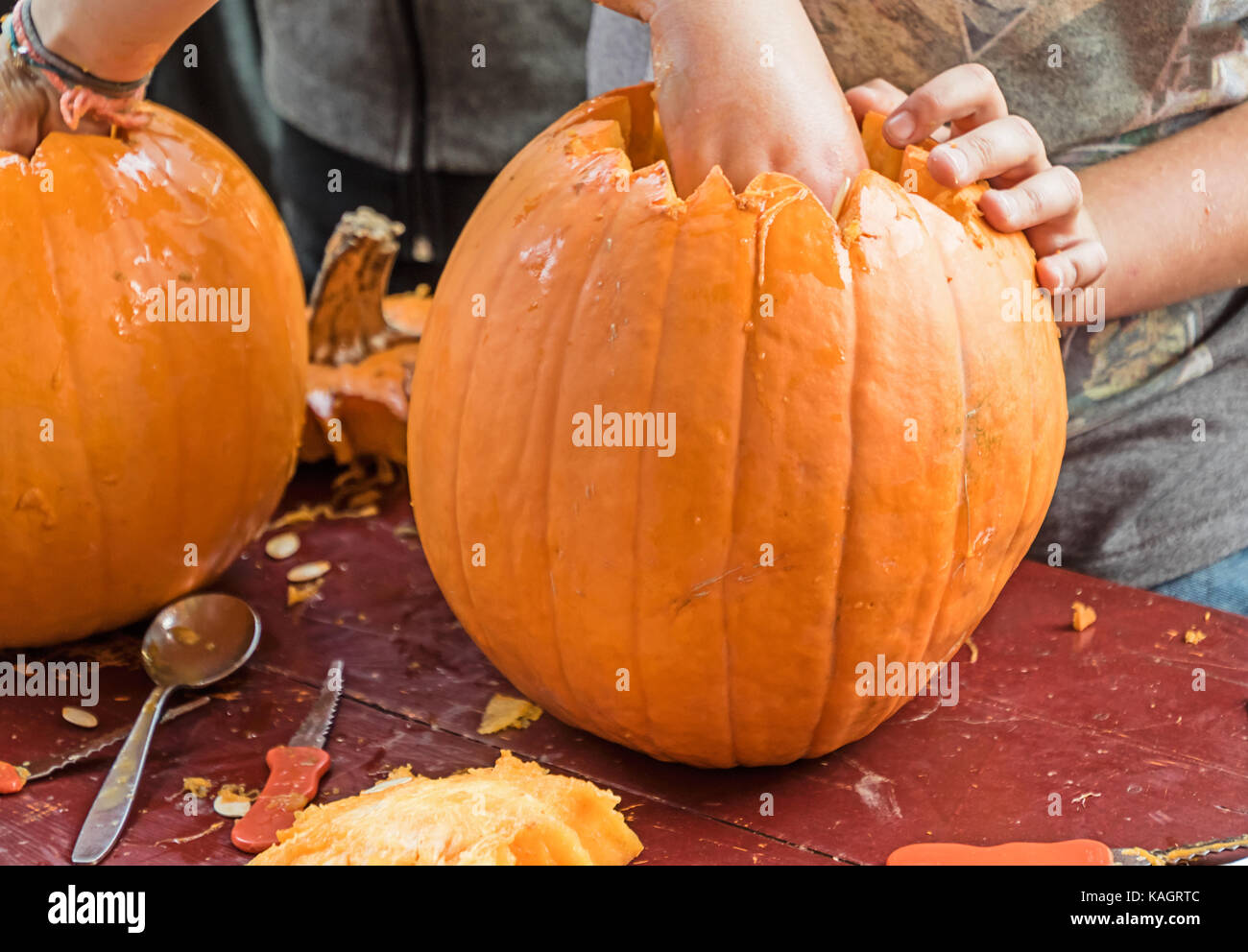 Bambini carving lanterne di halloween a una fattoria di zucca Foto Stock