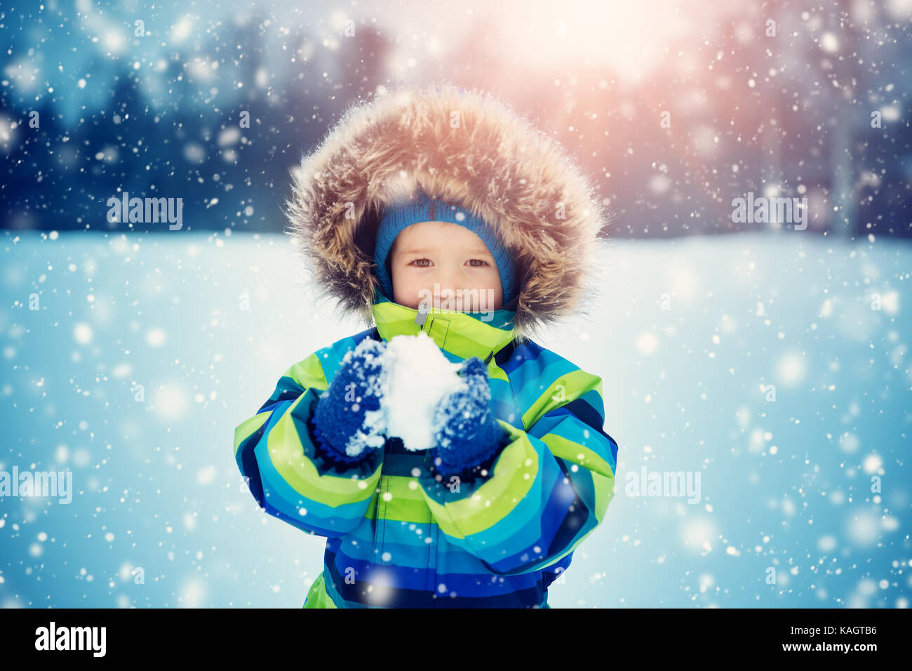 Ragazzo in maglia cappello, guanti e sciarpa in esterni al nevicata Foto Stock