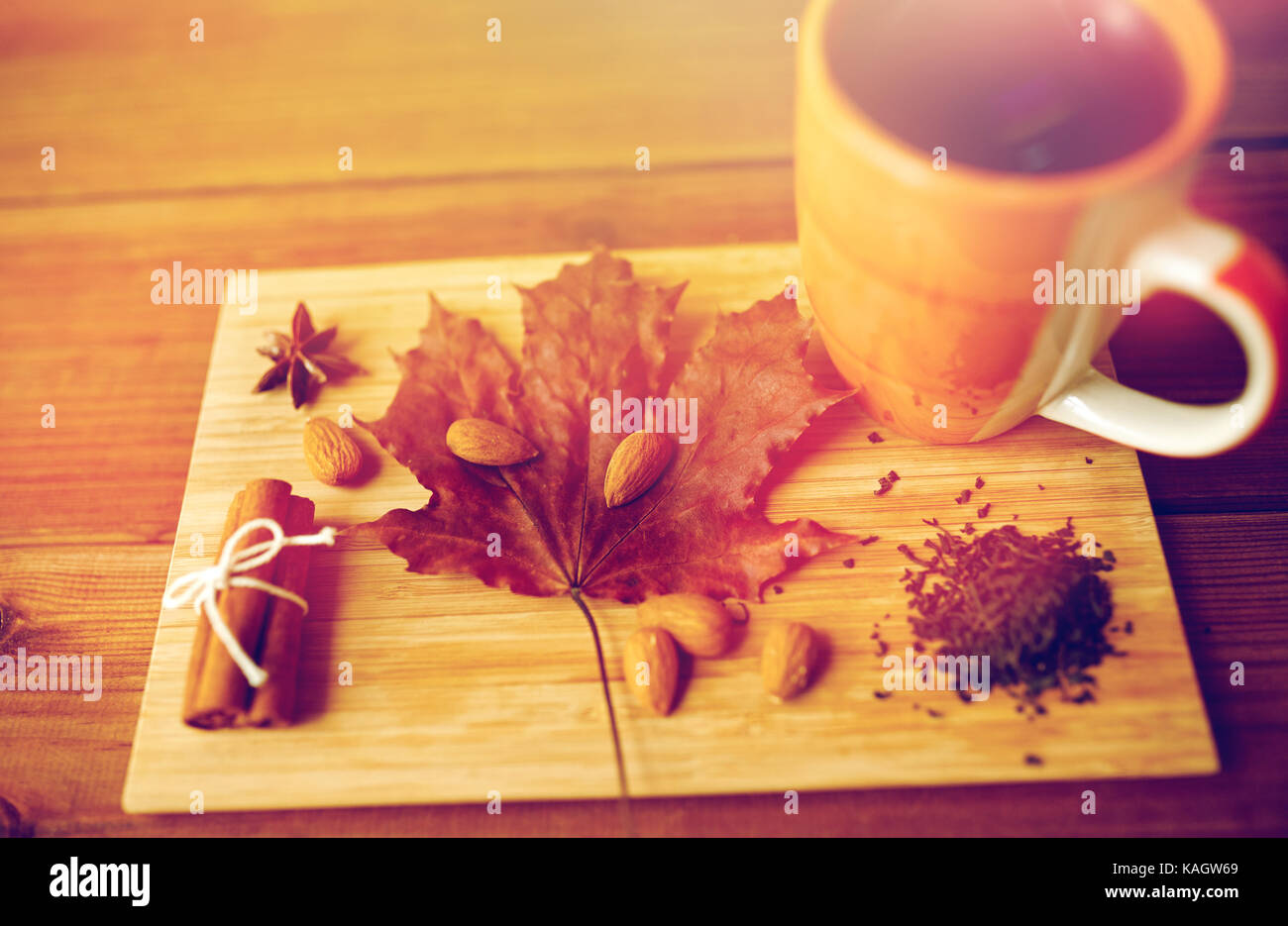 Tazza di tè, maple leaf e mandorla sul pannello di legno Foto Stock