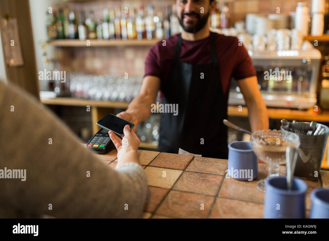 Man con il terminale di pagamento e la mano con lo smartphone Foto Stock