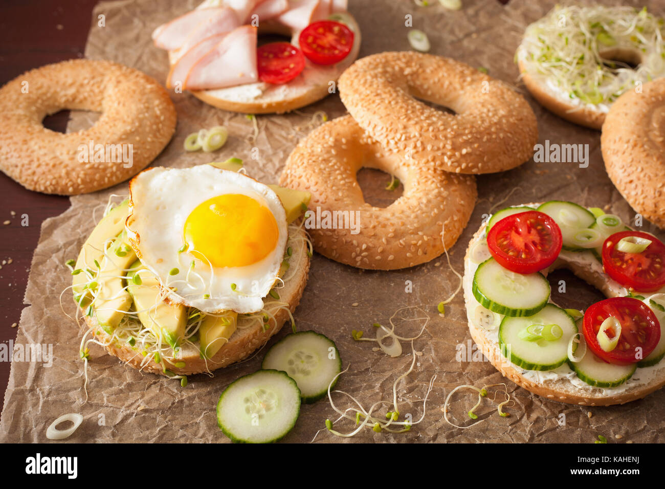 Varietà di panini su bagel: uovo, avocado, prosciutto, pomodoro, formaggio a pasta morbida, di germogli alfalfa Foto Stock