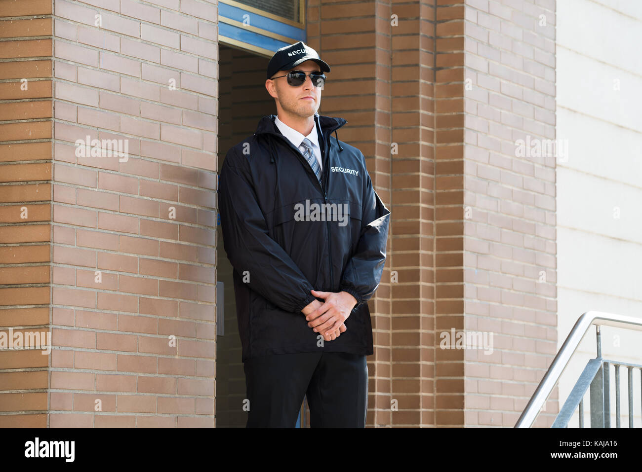Giovane maschio guardia di sicurezza in piedi all'ingresso Foto Stock