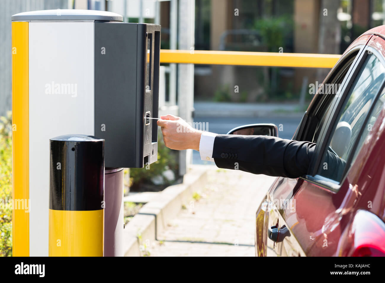 Uomo seduto in auto inserimento di biglietto per area di parcheggio Foto Stock