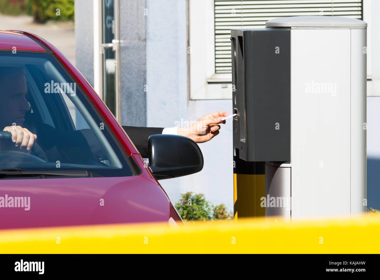 Uomo seduto in auto inserimento di biglietto per area di parcheggio Foto Stock