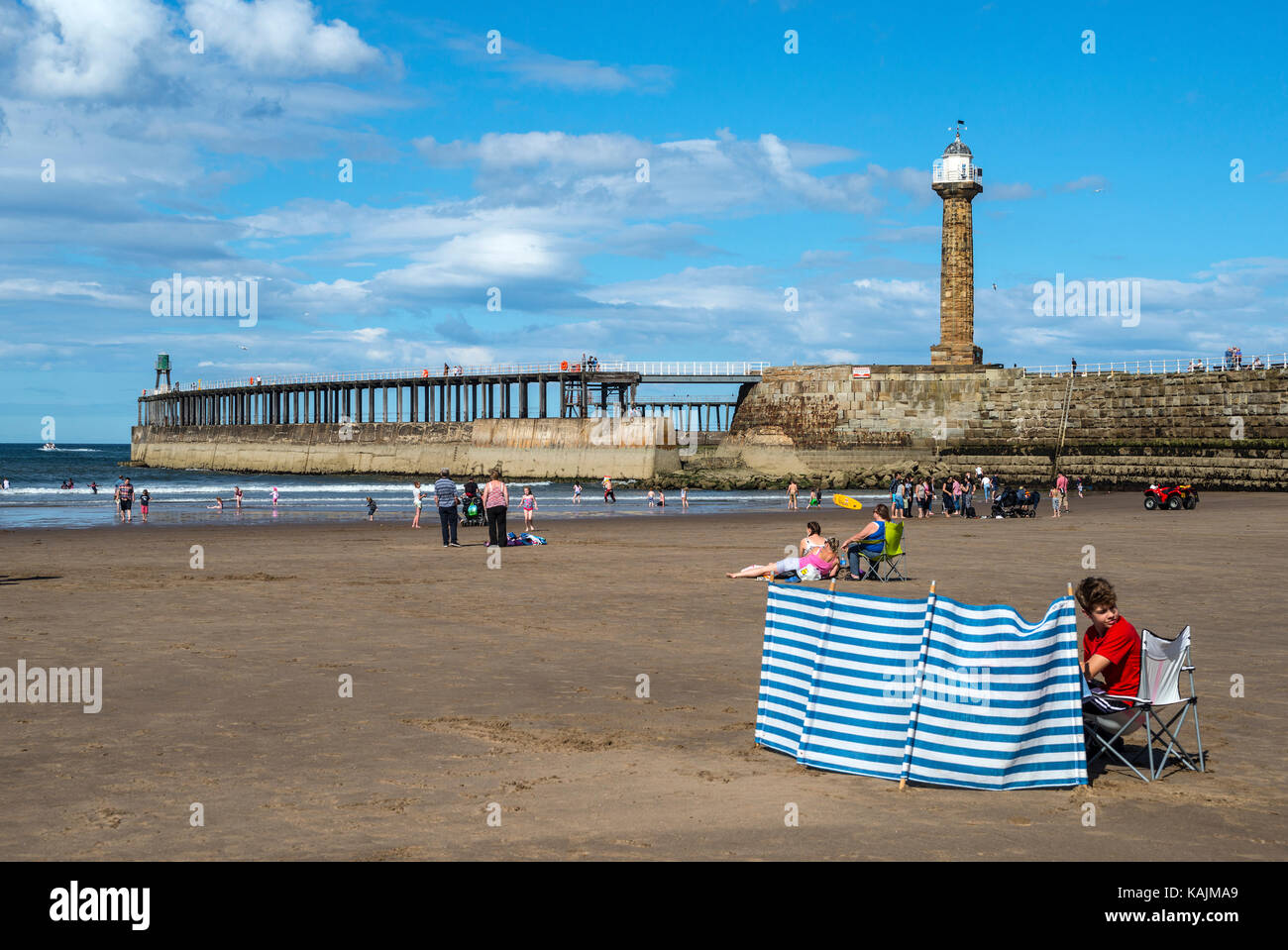 Whitby spiaggia con molo Ovest e frangiflutti, Whitby, North Yorkshire Foto Stock