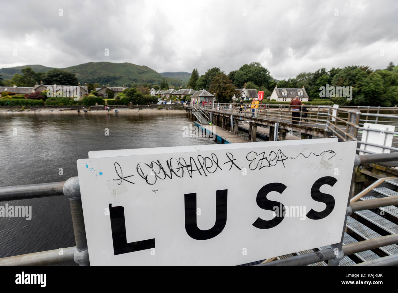 Tourist in the Luss Pier, sulla riva occidentale di Loch Lomond., Argyll & Bute, Scozia, Regno Unito Foto Stock