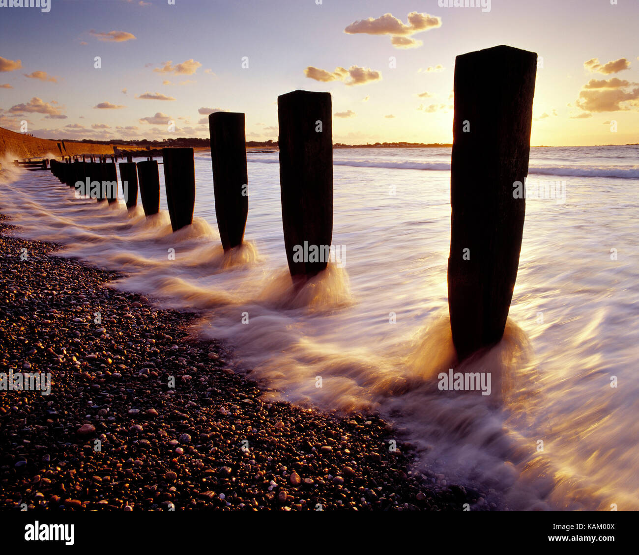 Isole del Canale. Guernsey. Vazon Bay. Onde sulla riva del mare con pennelli di legno. Foto Stock