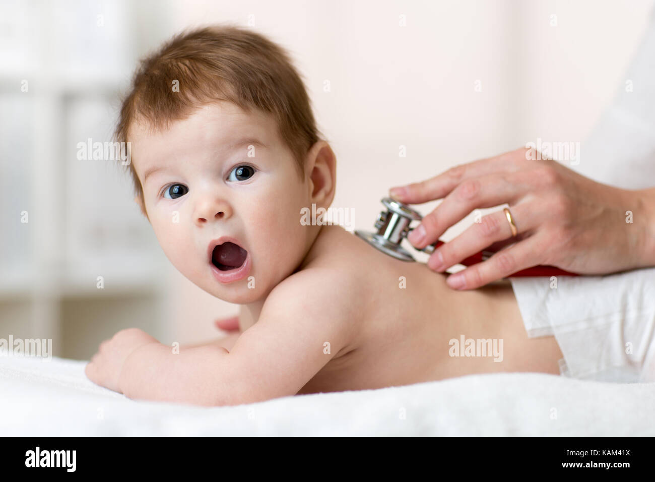 Pediatra esaminando bambino con uno stetoscopio Foto Stock