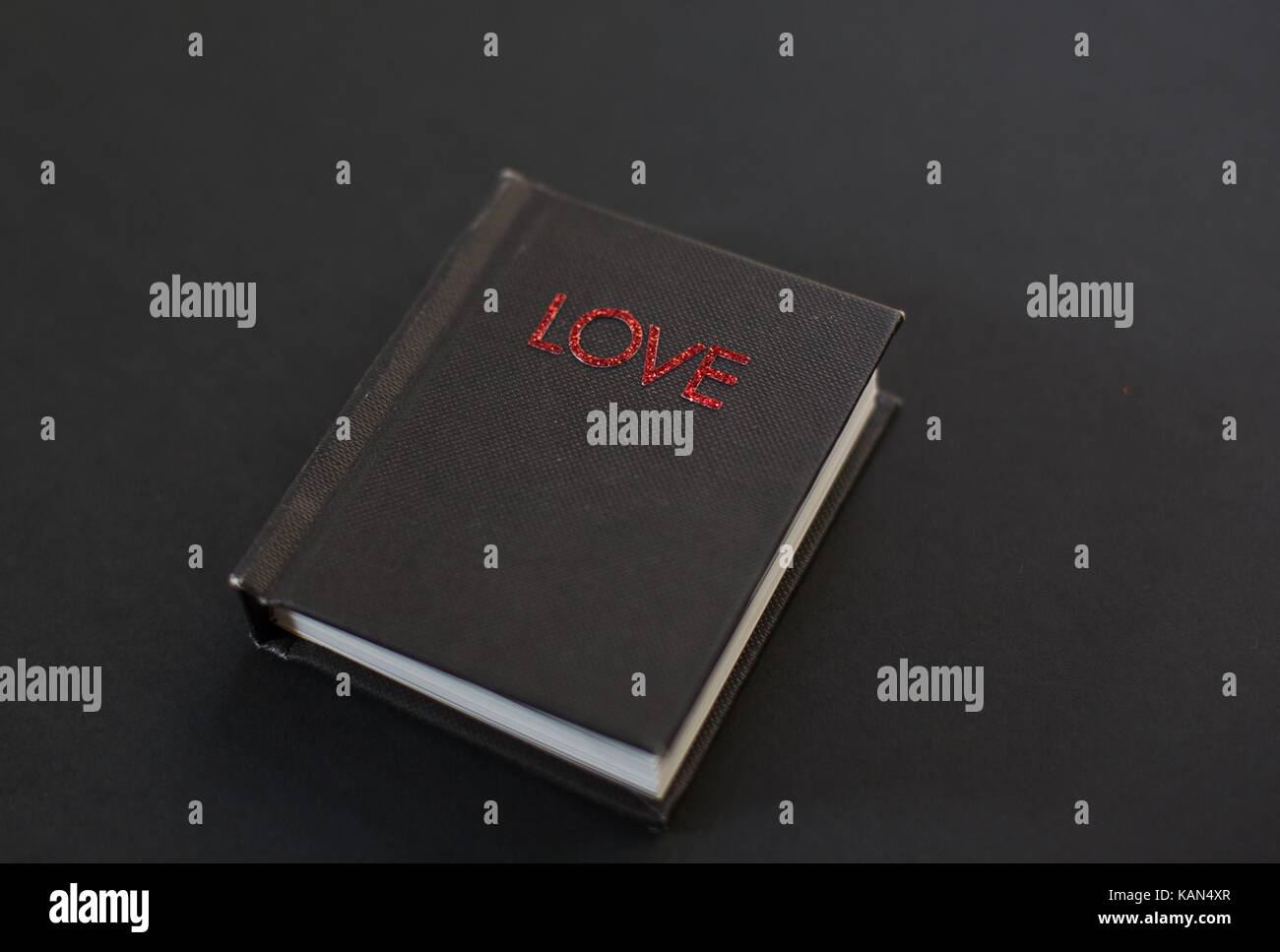 Un piccolo libro nero intitolato "L'amore". Foto Stock