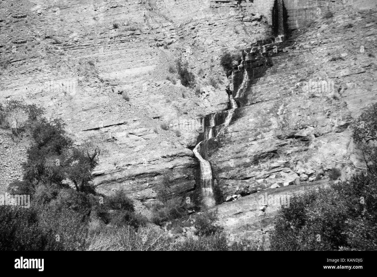 Una foto in bianco e nero di un ruscello che scorre su di un versante della montagna. Foto Stock