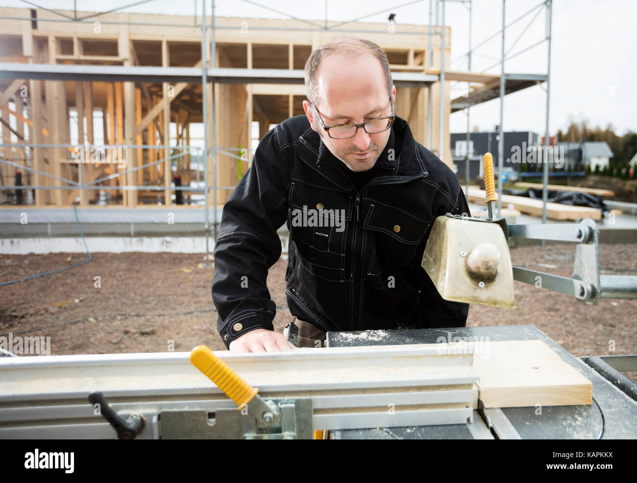 Carpenter utilizzando la tabella sega per tagliare il listone presso il sito Foto Stock