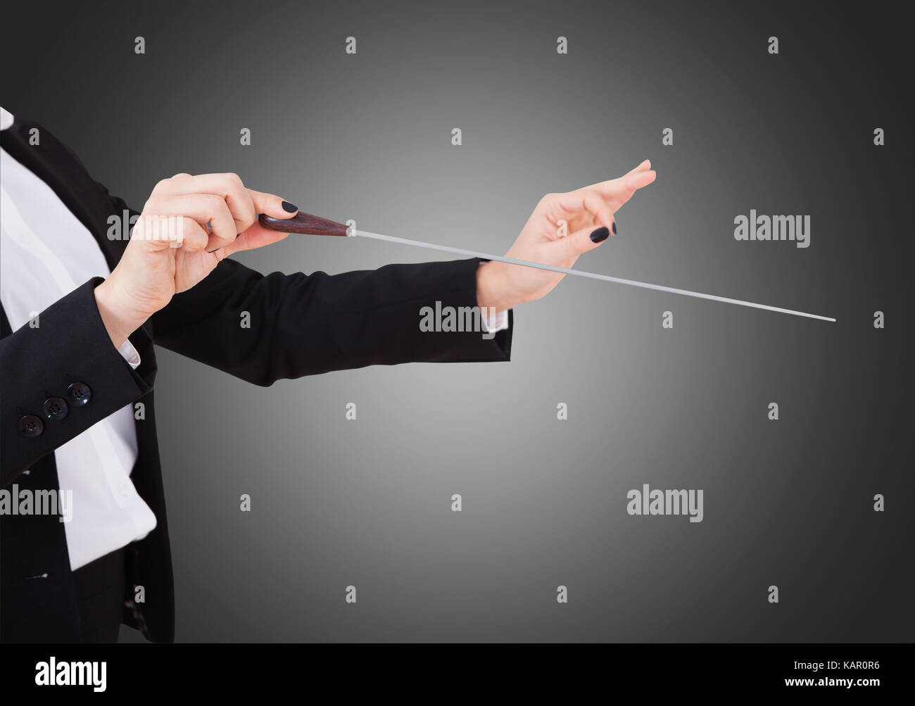 Immagine ritagliata della musica femminile del conduttore mani testimone contro uno sfondo grigio Foto Stock