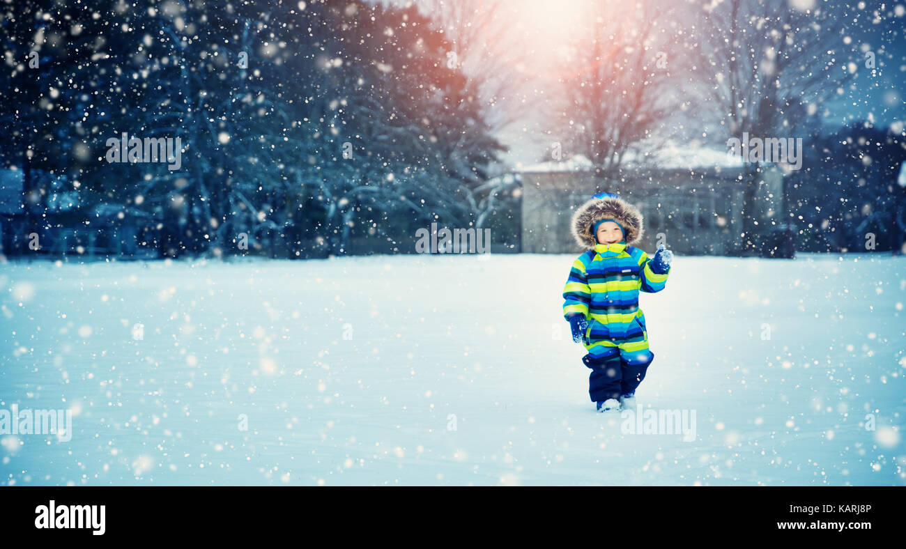 Ragazzo in maglia cappello, guanti e sciarpa in esterni al nevicata Foto Stock