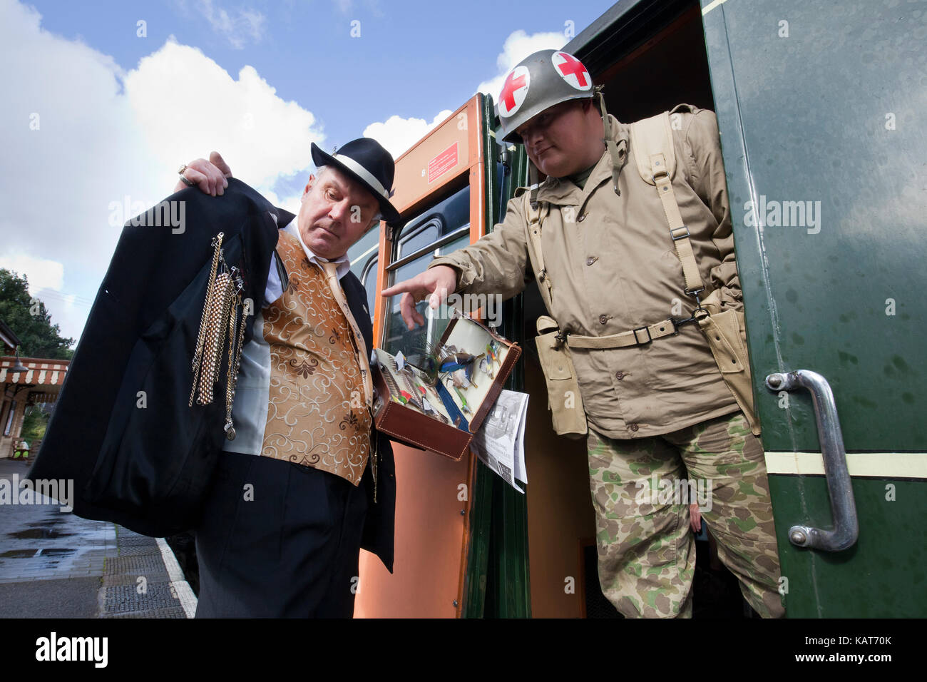 Interpretazione del tempo di guerra spiv vendere al mercato nero il contrabbando di una croce rossa volontari su nord stazione di Norfolk nel Regno Unito. Foto Stock