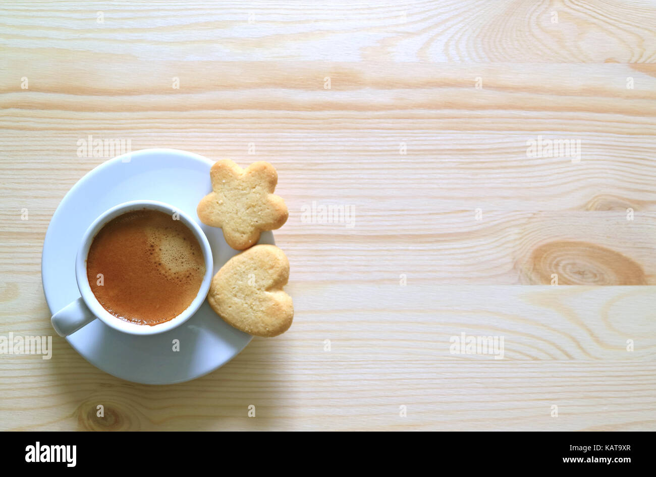 Vista dall'alto di due biscotti al burro con una tazza di caffè sul tavolo in legno Foto Stock