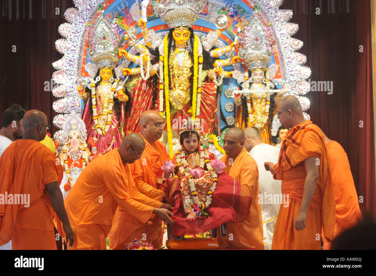 Un sacerdote indiano adora cinque anni ragazza indù , vestita come la dea Indù durga, a belur math per la 'kumari' puja rituala durante la durga puja festival . Foto Stock