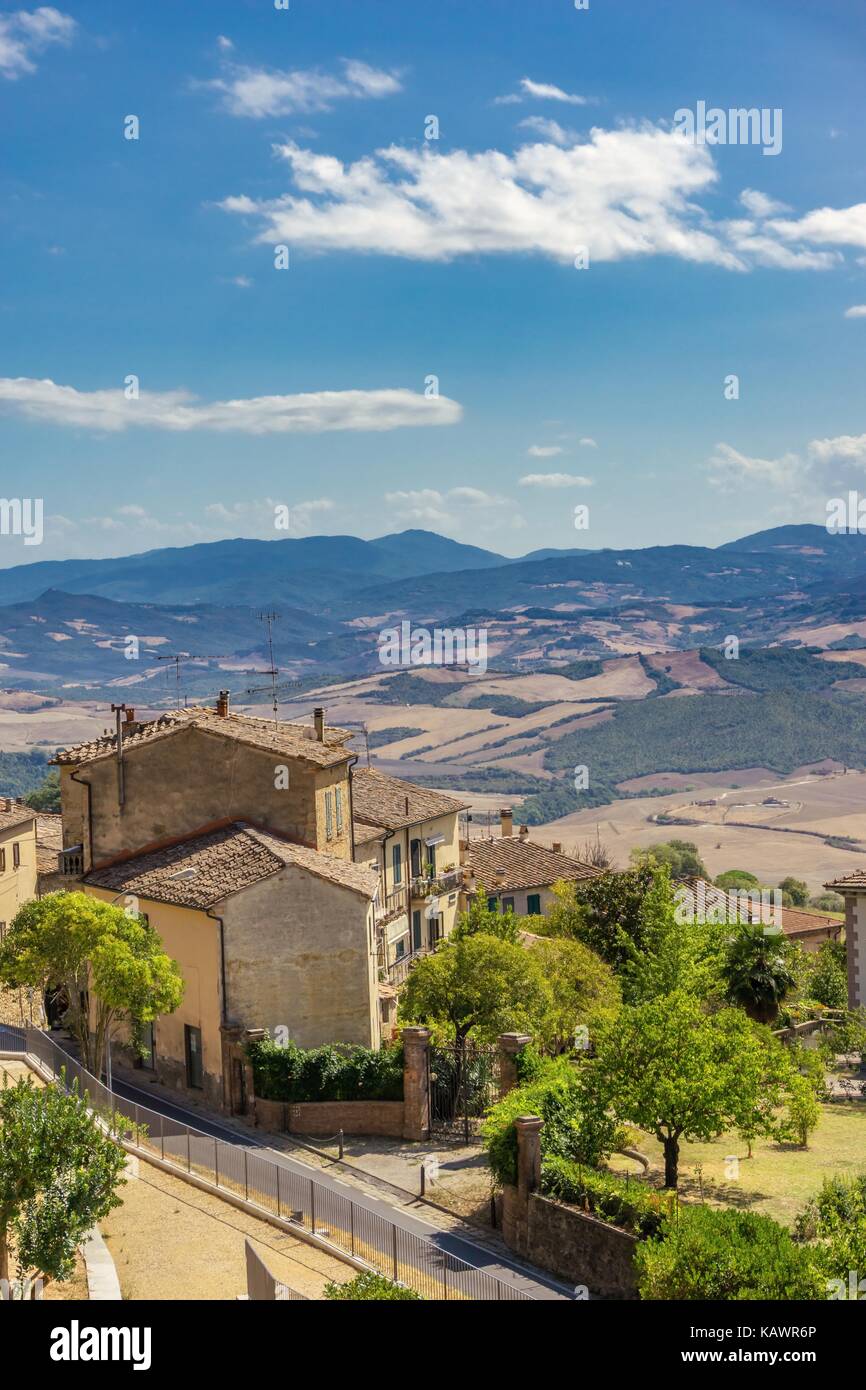 Foto verticale con il vecchio rustico che è costruito sul lato della città storica in toscana italia. il paesaggio con le colline, rocce, alberi di olivo e foresta Foto Stock