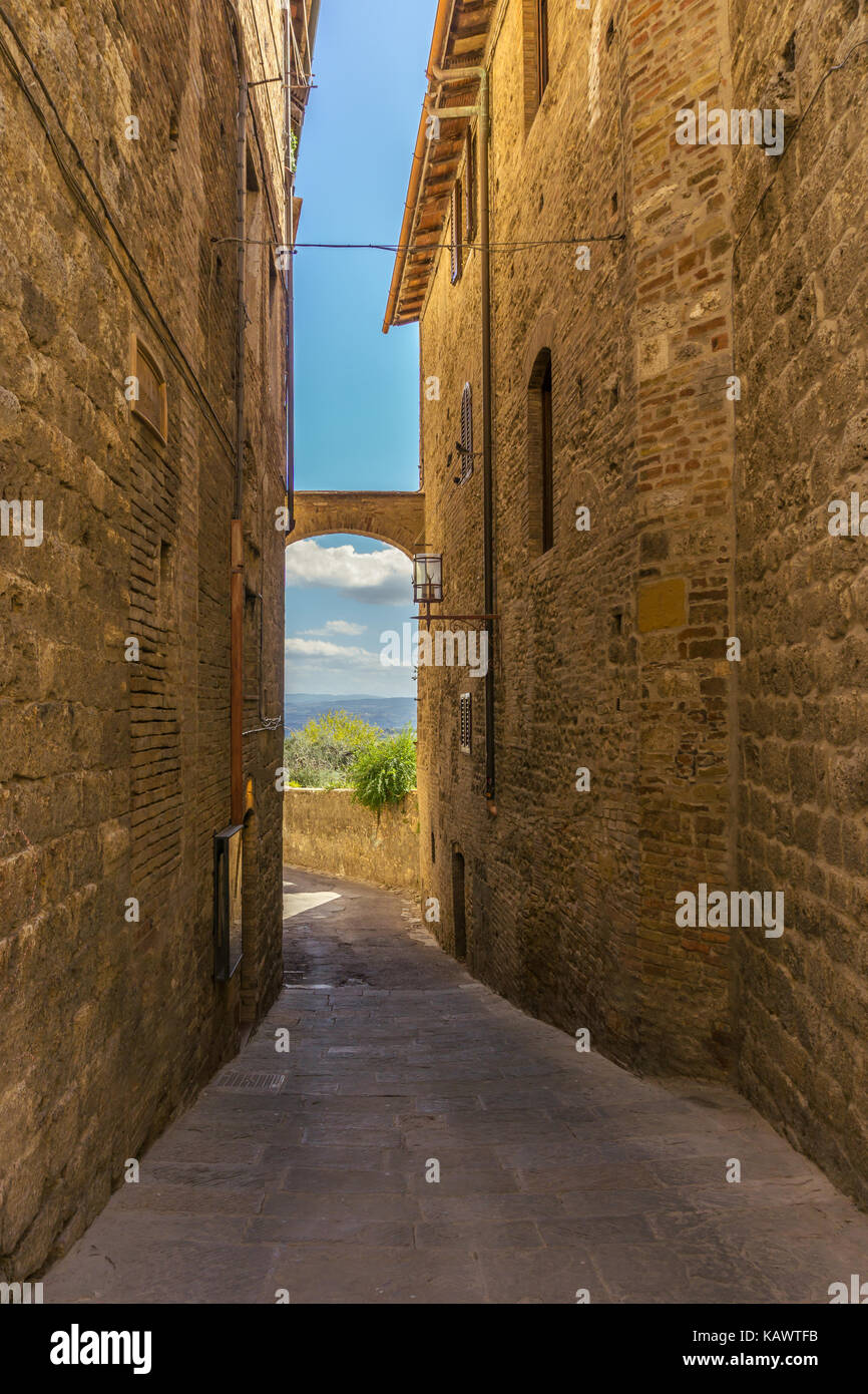 Foto verticale con vista nella piccola strada stretta. Gli edifici sono costruiti dal tuf vulcanica tipica pietra per la toscana in Italia. La vista tra hous Foto Stock