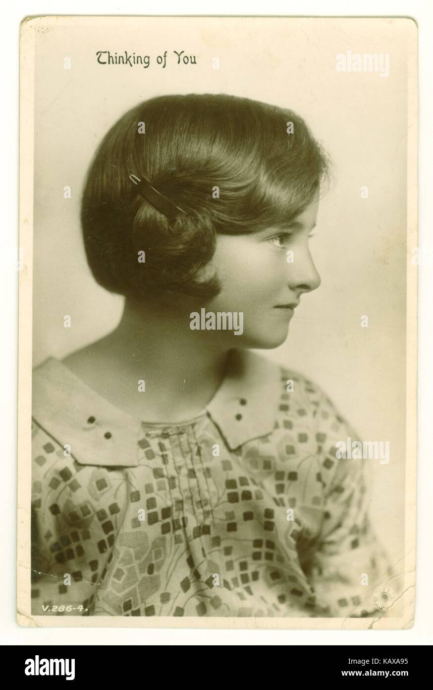 Cartolina originale del 1920s di saluti della ragazza giovane graziosa dei primi anni dell'adolescenza, con i capelli della bobina, che indossa un vestito della festa, circa 1925 U.K. Foto Stock