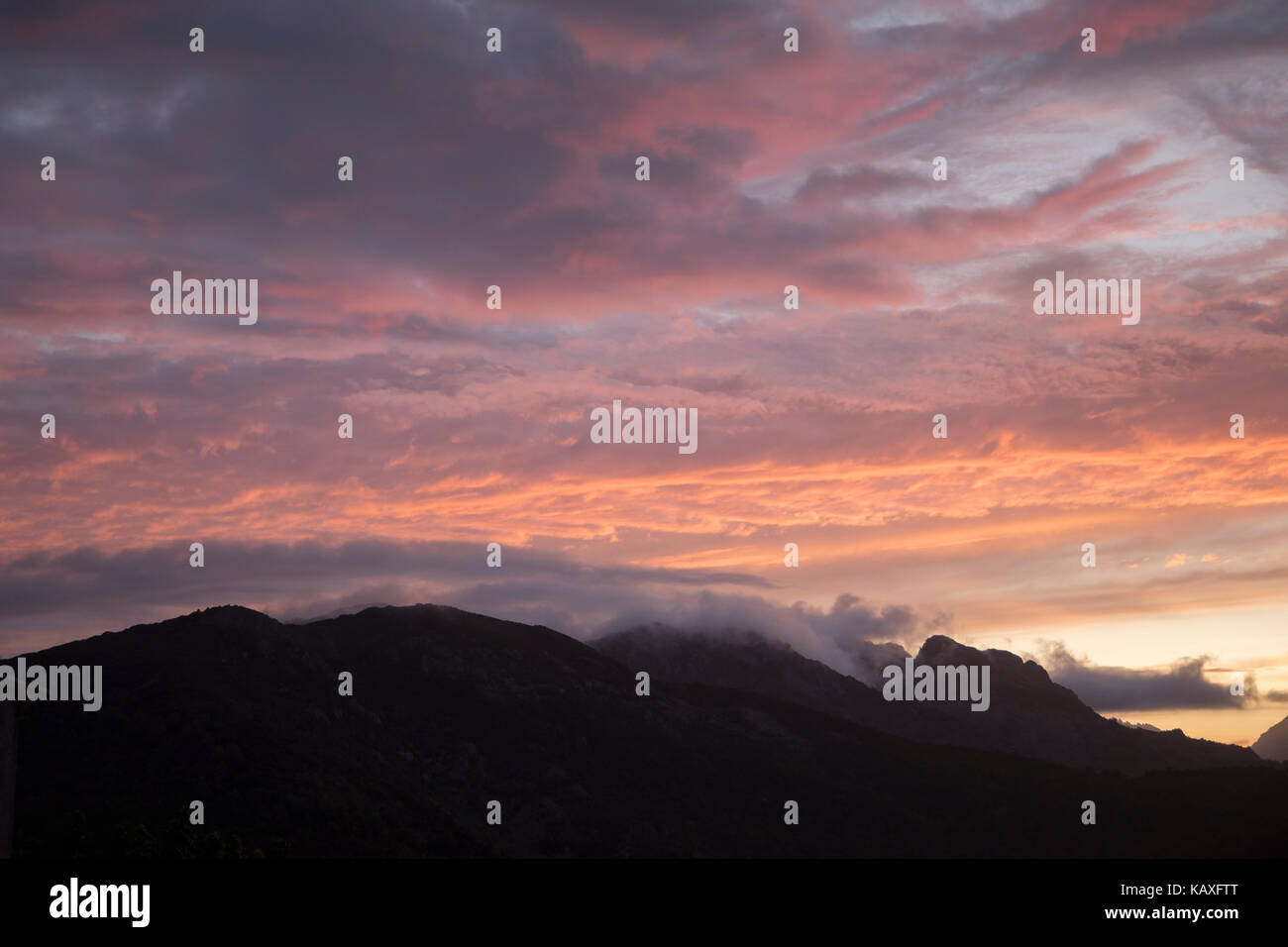 Panorama al tramonto guardando lungo le montagne e la campagna verso la costa ovest da marignana, Corsica, Francia. La Corsica è un'isola del Mediterraneo e una delle 18 regioni della Francia e si trova a sud-est della Francia continentale e ad ovest della penisola italiana. Foto Stock