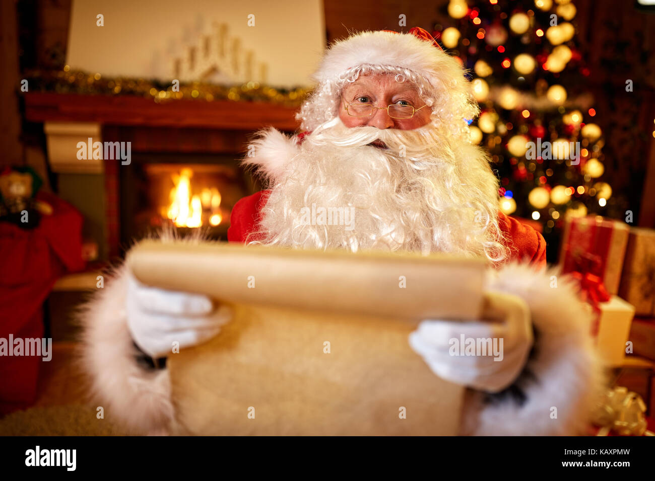 Babbo Natale con un elenco dei bambini auguri per i regali di natale Foto Stock
