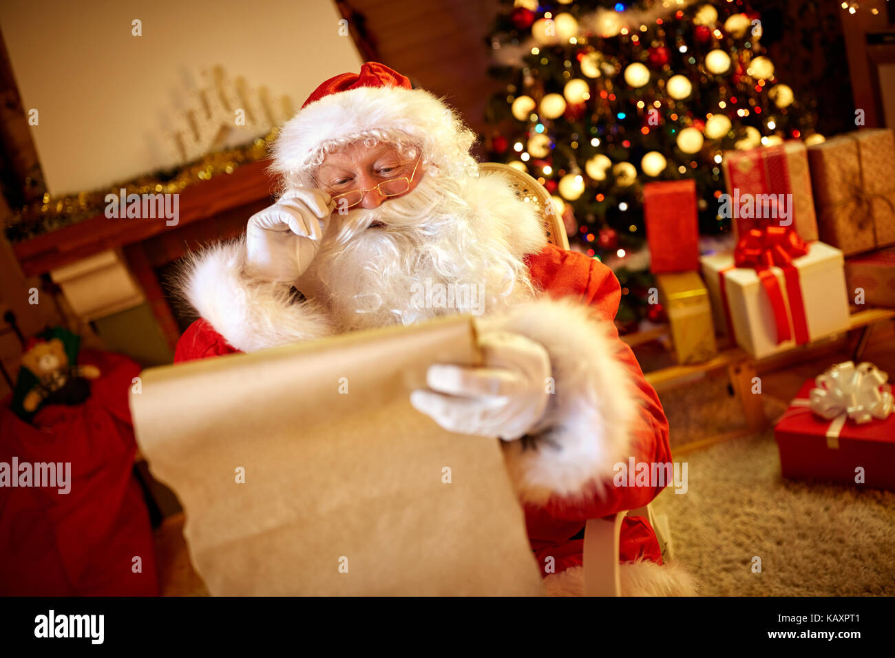 Santa Claus guardando al lungo elenco con i bambini il desiderio per il regalo di natale Foto Stock