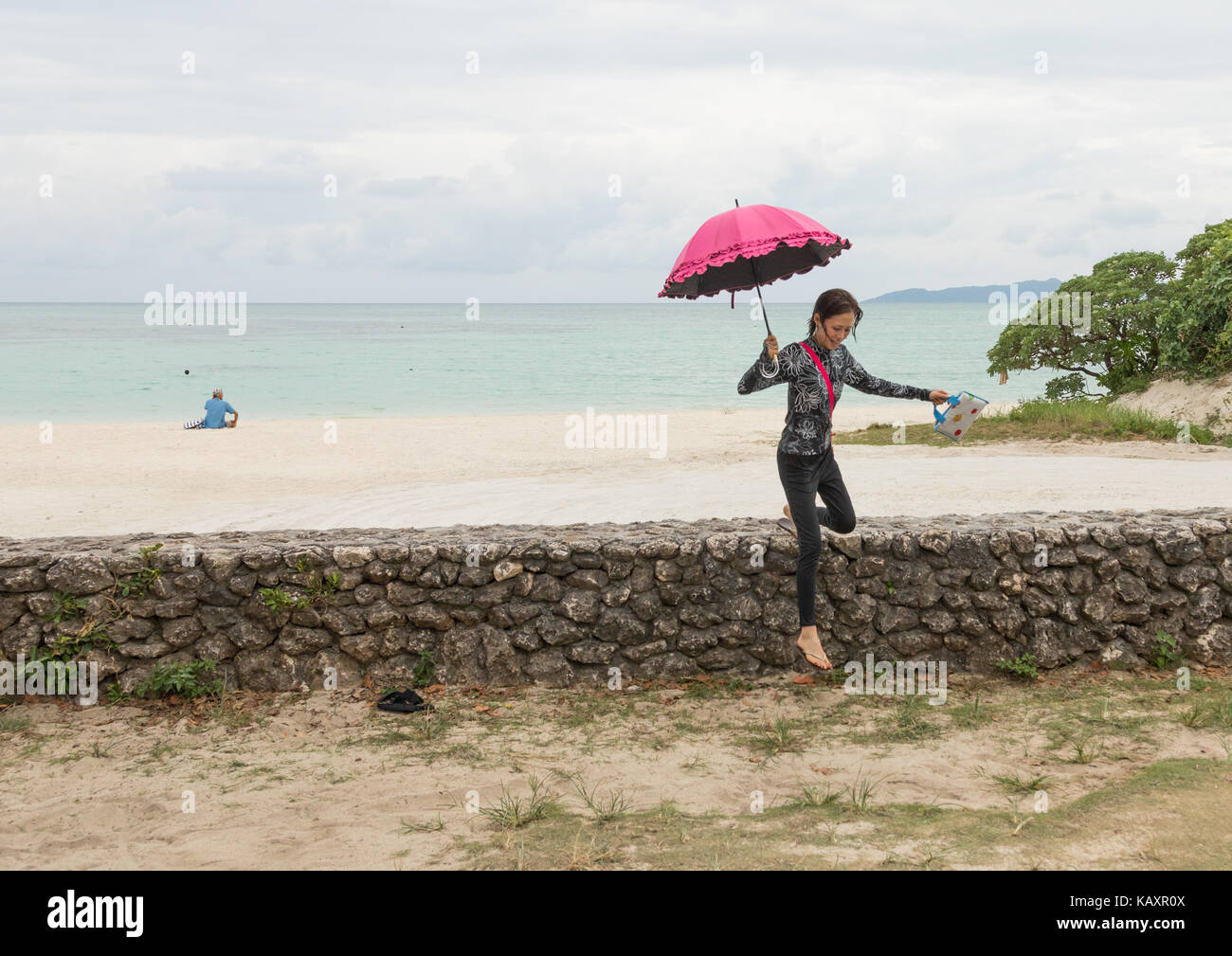 Donna giapponese con un ombrellone in spiaggia kondoi, isole yaeyama, Isola di Taketomi, Giappone Foto Stock