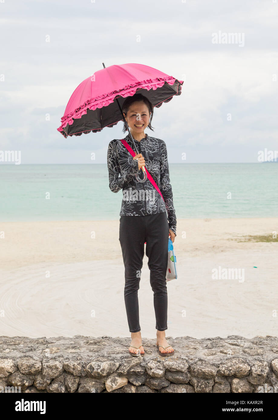 Donna giapponese con un ombrellone in spiaggia kondoi, isole yaeyama, Isola di Taketomi, Giappone Foto Stock