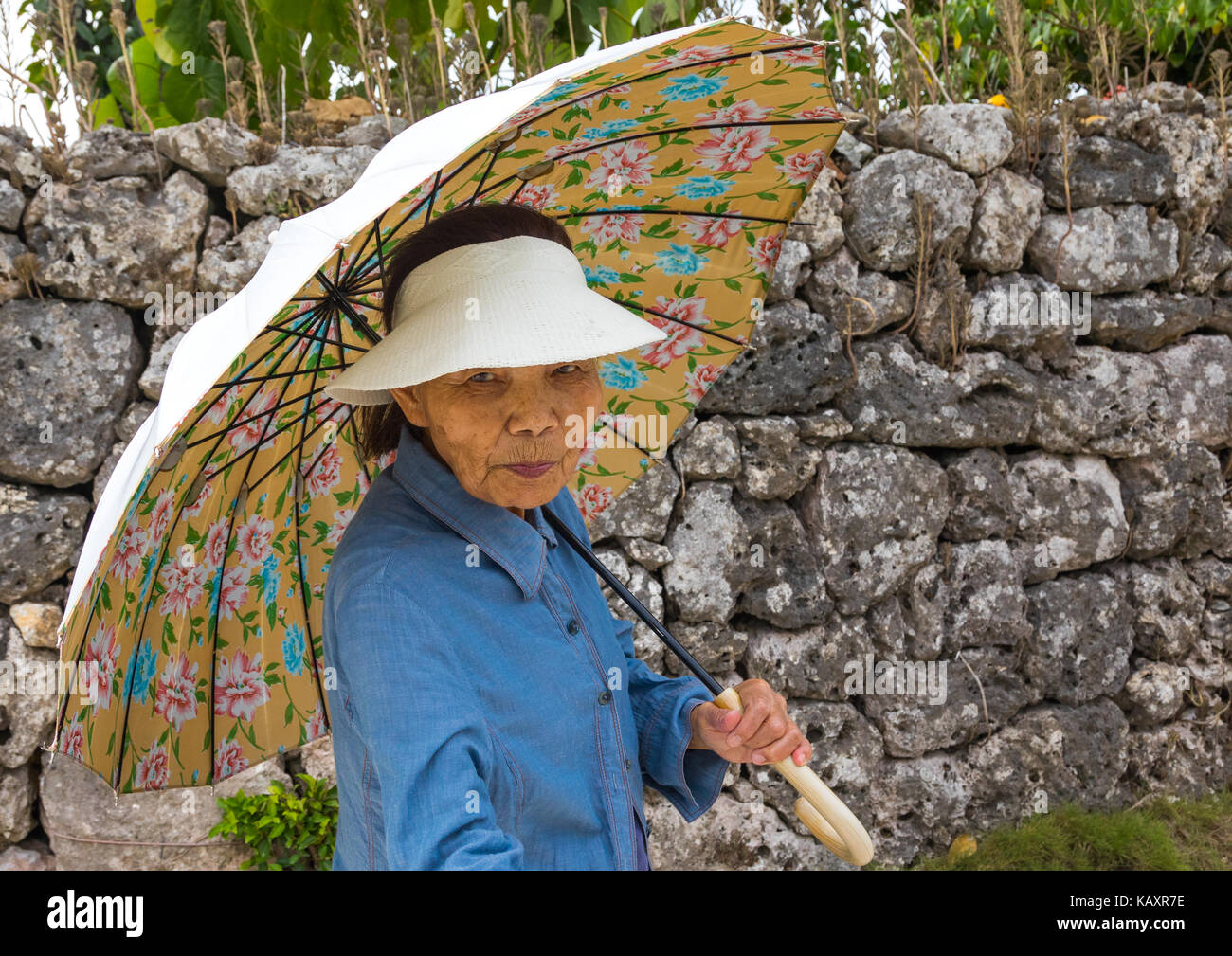 Senior donna giapponese con un ombrello, isole yaeyama, Isola di Taketomi, Giappone Foto Stock