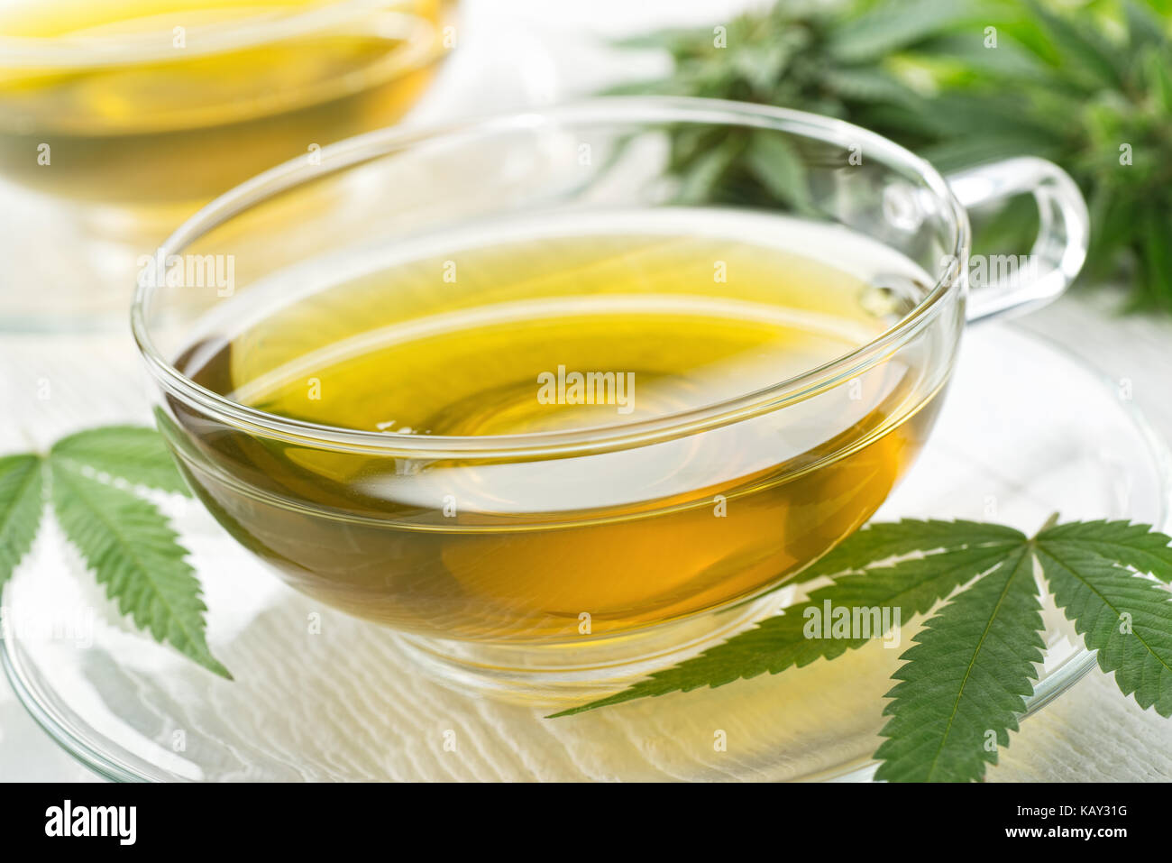 Una tazza di marijuana a caldo tè con boccioli e foglie. Foto Stock