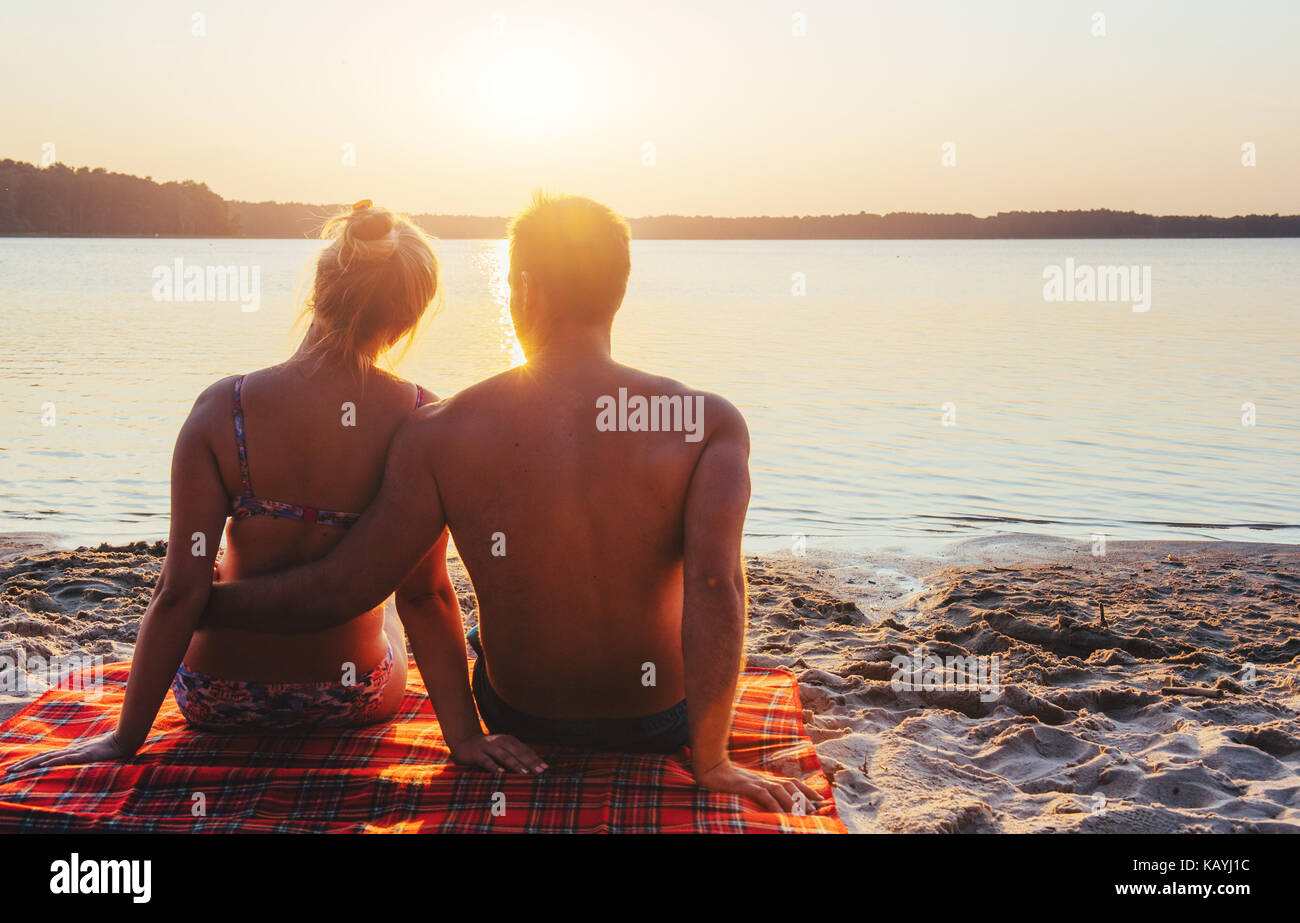 Coppia romantica sulla spiaggia al tramonto colorato su sfondo Foto Stock