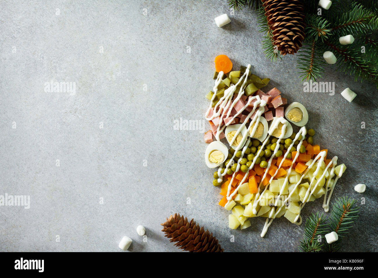 Albero di Natale fatto da insalata olivier su un livello di grigio ardesia e pietra o metallo dello sfondo. Splendido Natale e Anno Nuovo sfondo per cibo vista dall'alto di un Foto Stock