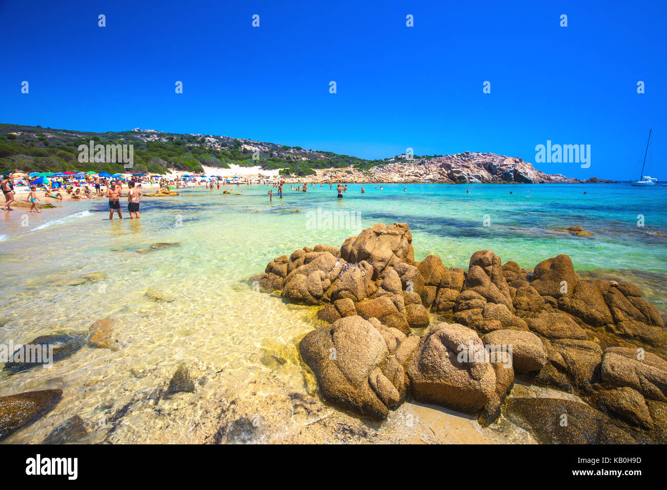 Cala Cipolla, chia spiaggia con pietre di colore rosso e azzurro acqua chiara. La Sardegna è la seconda isola più grande del Mediterraneo. Foto Stock