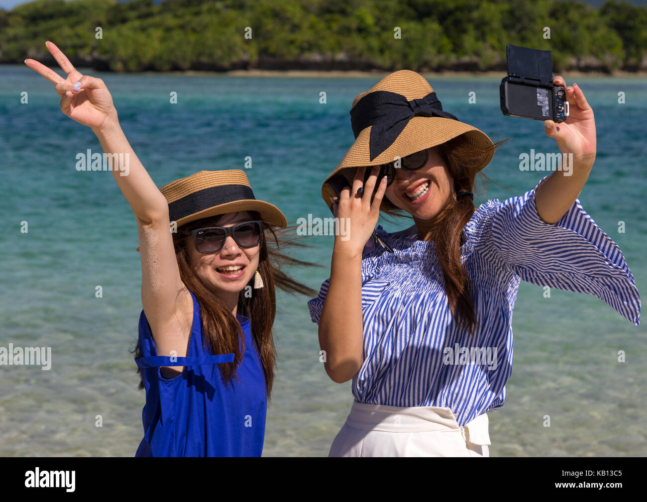 Le ragazze giapponesi hanno tenuto selfie nella laguna tropicale con chiare acque blu nella baia di kabira, isole yaeyama, ishigaki, Giappone Foto Stock